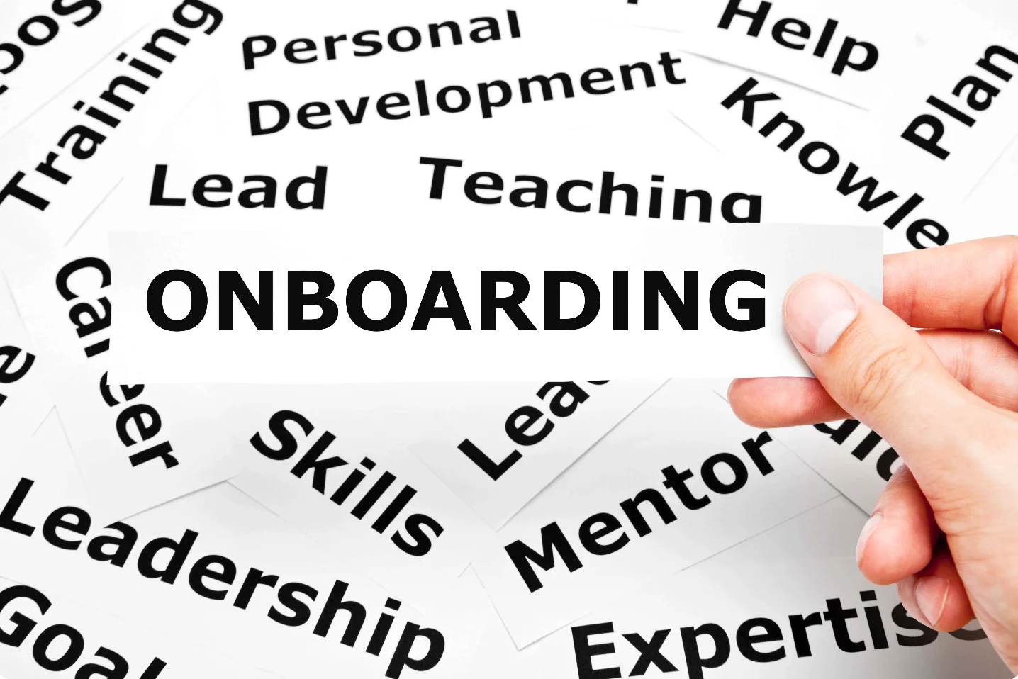 Sign 'Onboarding' held in hand above other qualities including personal development, skills, leadership.